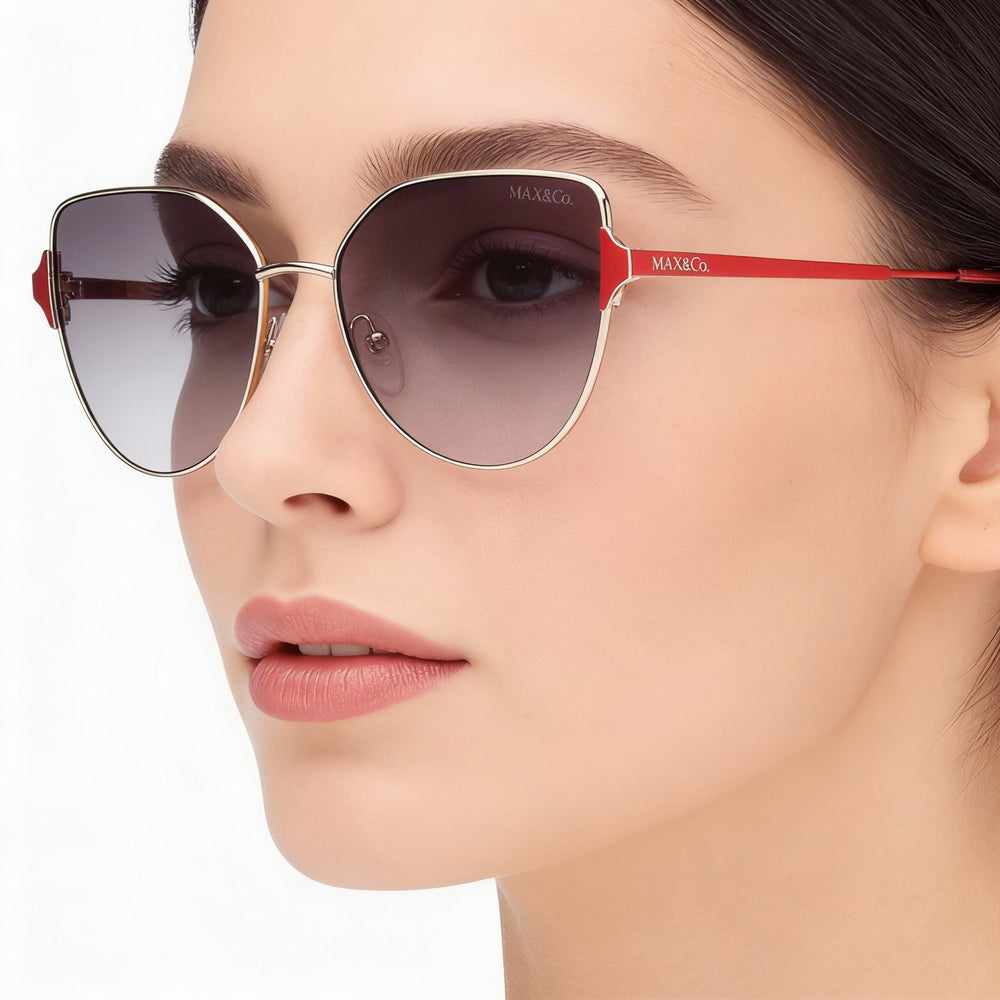 Gafas de sol modernas Max & Co. para mujer, montura de metal dorado con lentes de 57 mm no polarizadas con protección UV y efecto ahumado degradado.