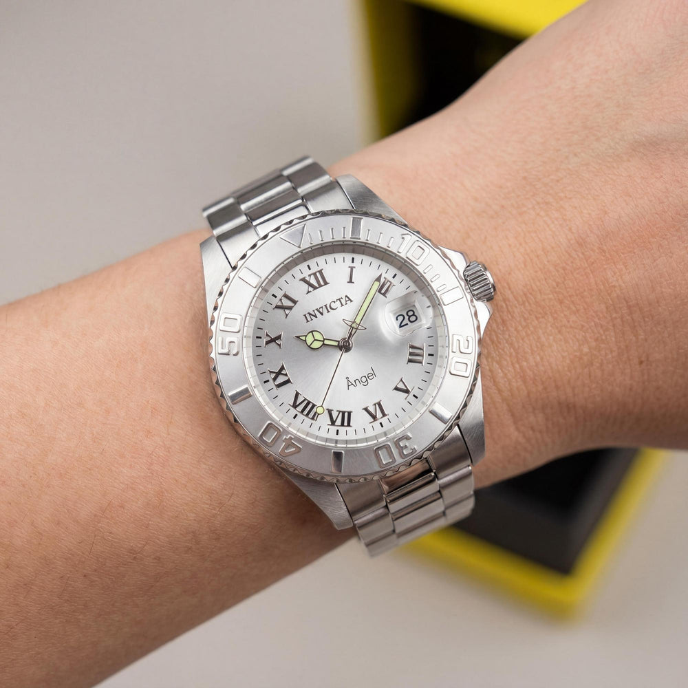 Reloj Invicta para mujer, de acero inoxidable, esfera plateada, cuarzo, resistente al agua hasta 20 bares, con brillantina en la oscuridad y marcas en el bisel.